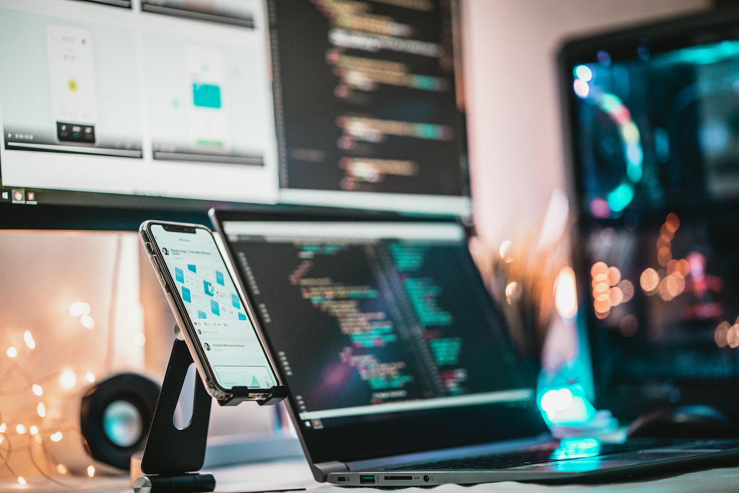 Desk with laptop, monitors, and smartphone in a tech workspace.